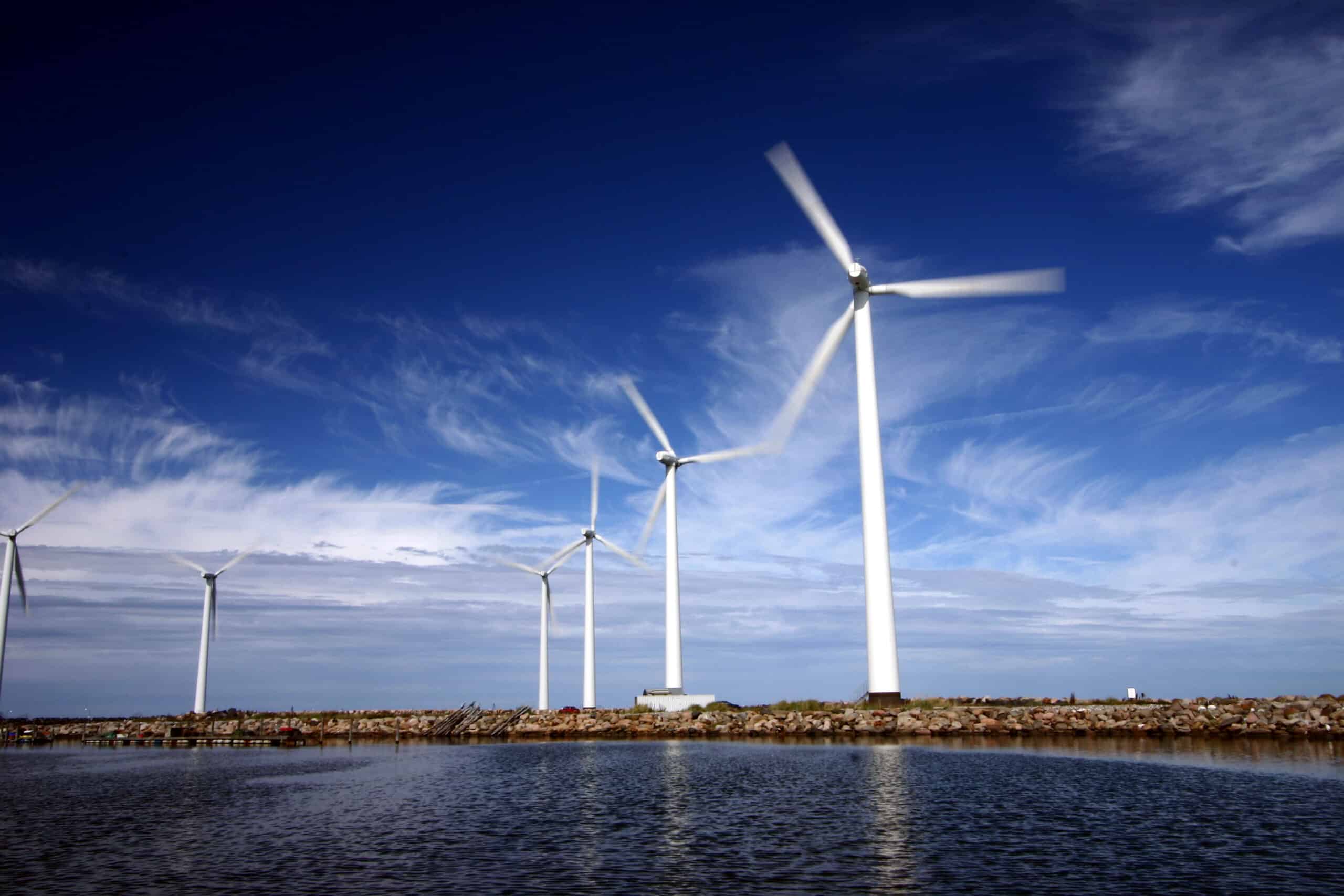Wind mills in the ocean with a blue sky