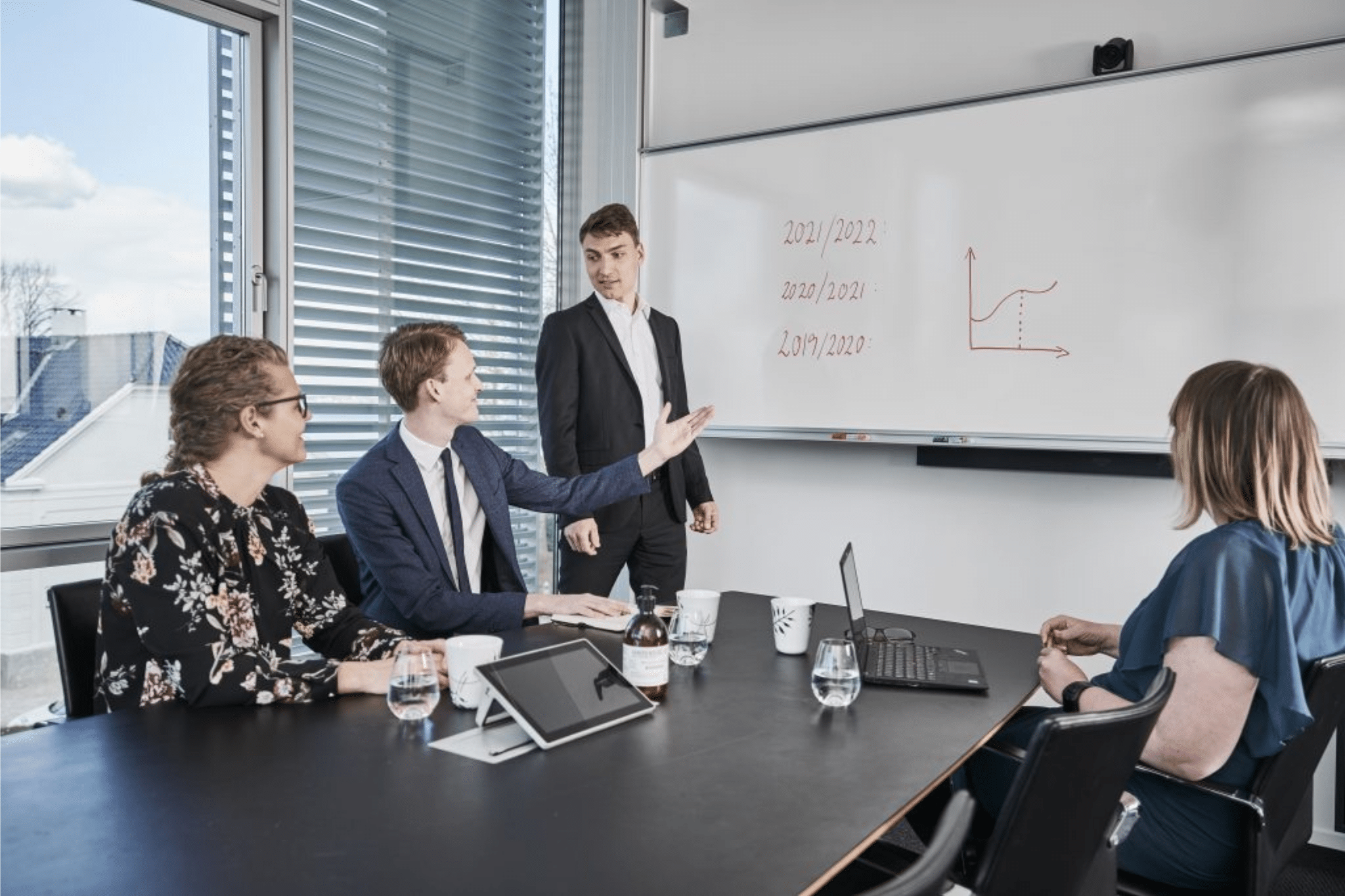 people in a meeting looking at a white board 