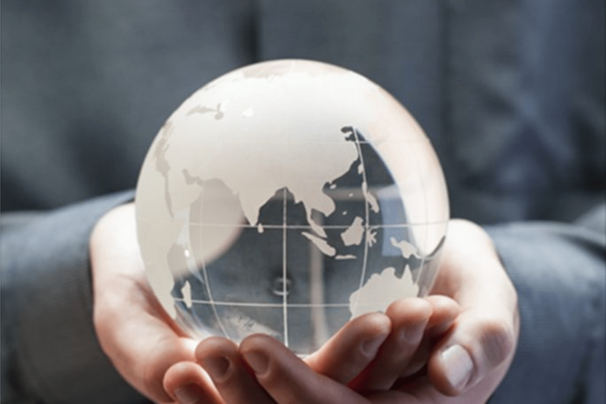 hands holding a transparent globe with the countries of the world