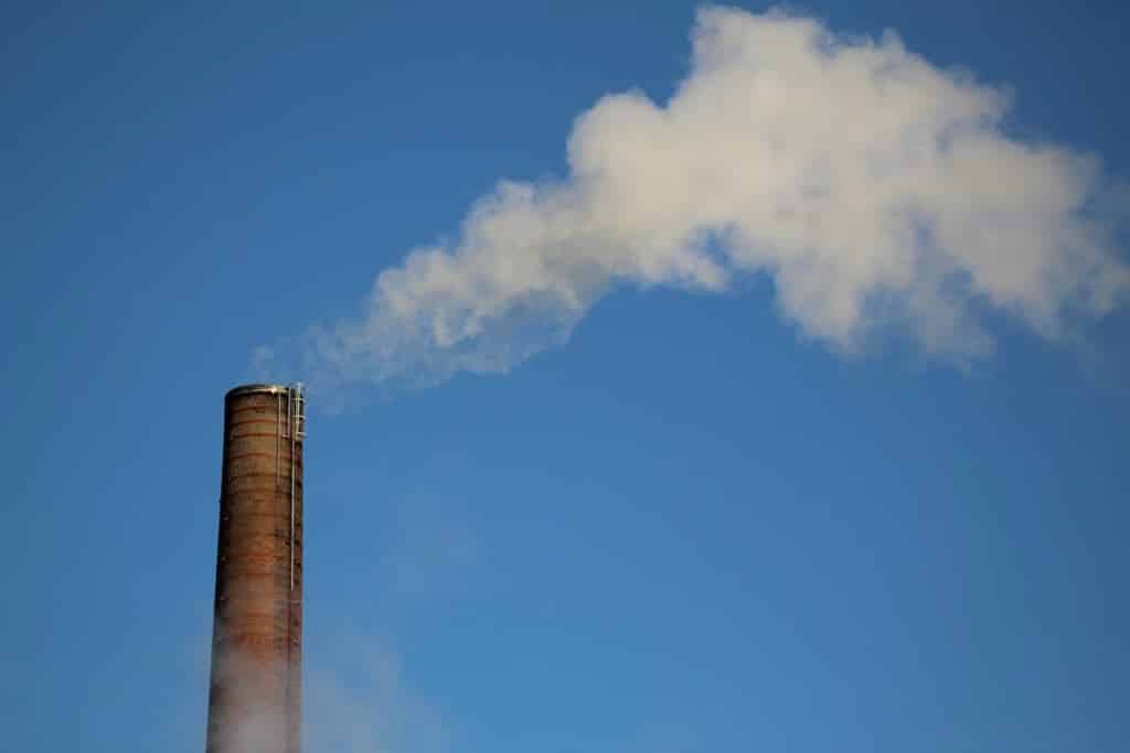 chimney with smoke rising with blue sky
